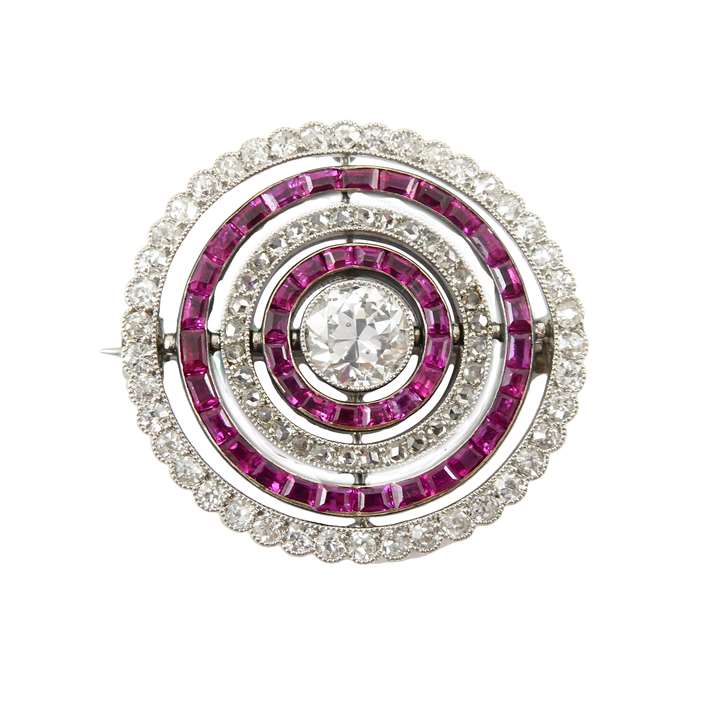 Early 20th century diamond and ruby swivelling target cluster brooch, Cartier, probably Paris, c.1910, with a central old round brilliant cut diamond of approximately 0.85ct,